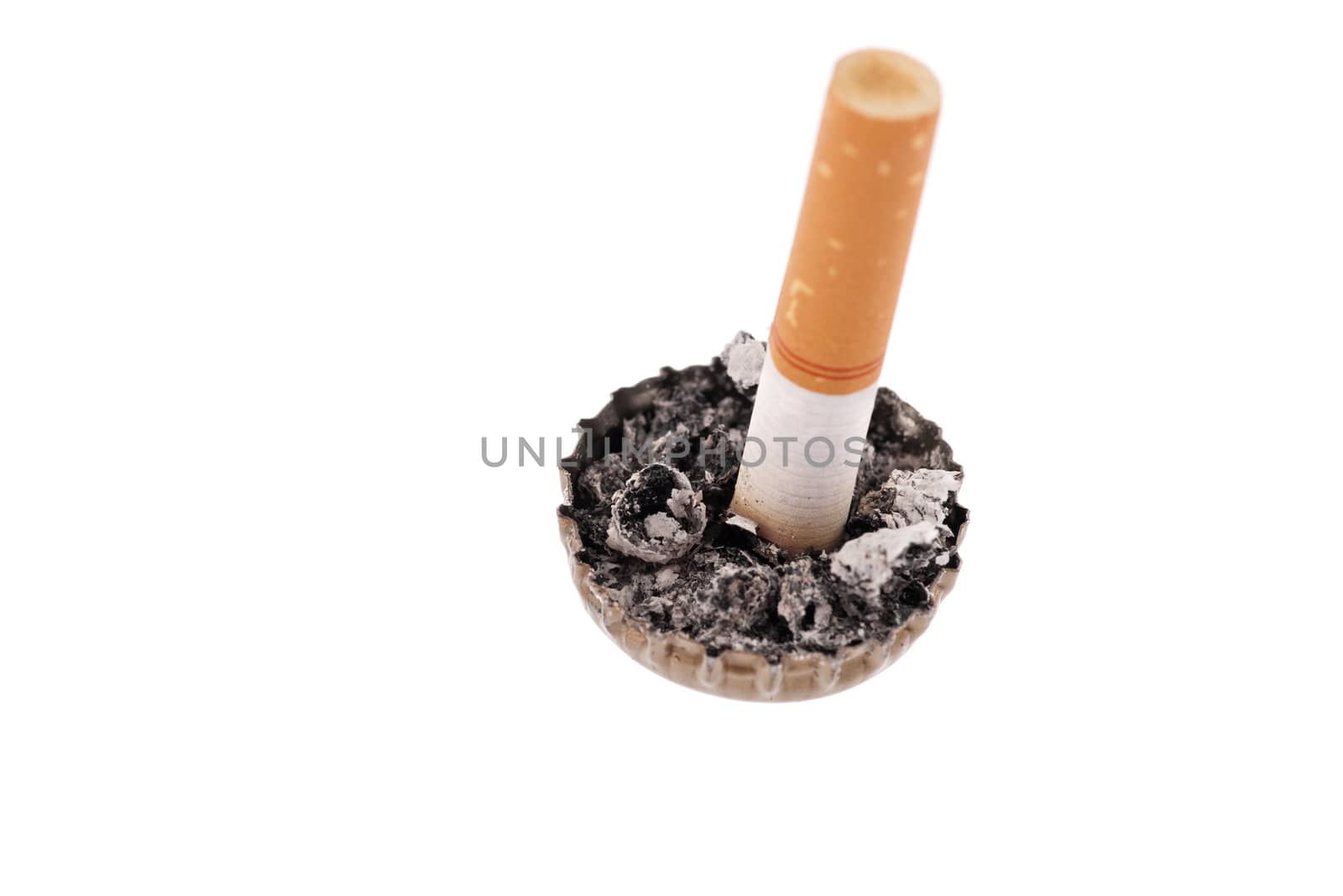 Quit smoking, cigarette butt in a bottle cap on white background