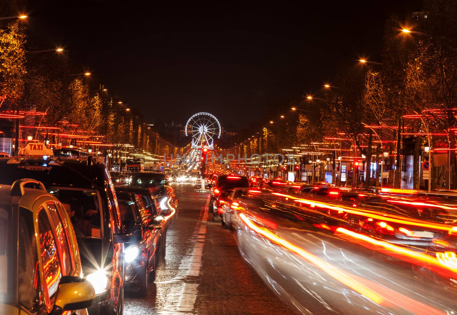 December illumination and traffic lights on the Avenue des Champs-Élysées in Paris,Europe. In the distance you can see the Ferry wheel located in Place de la Concorde.