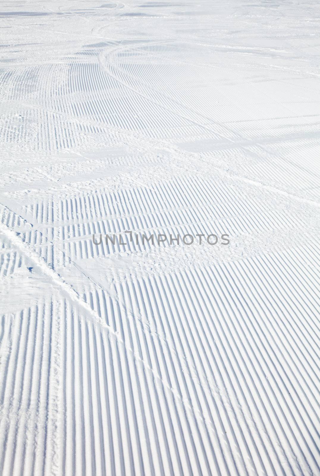 Ski tracks on a fresh groomed piste