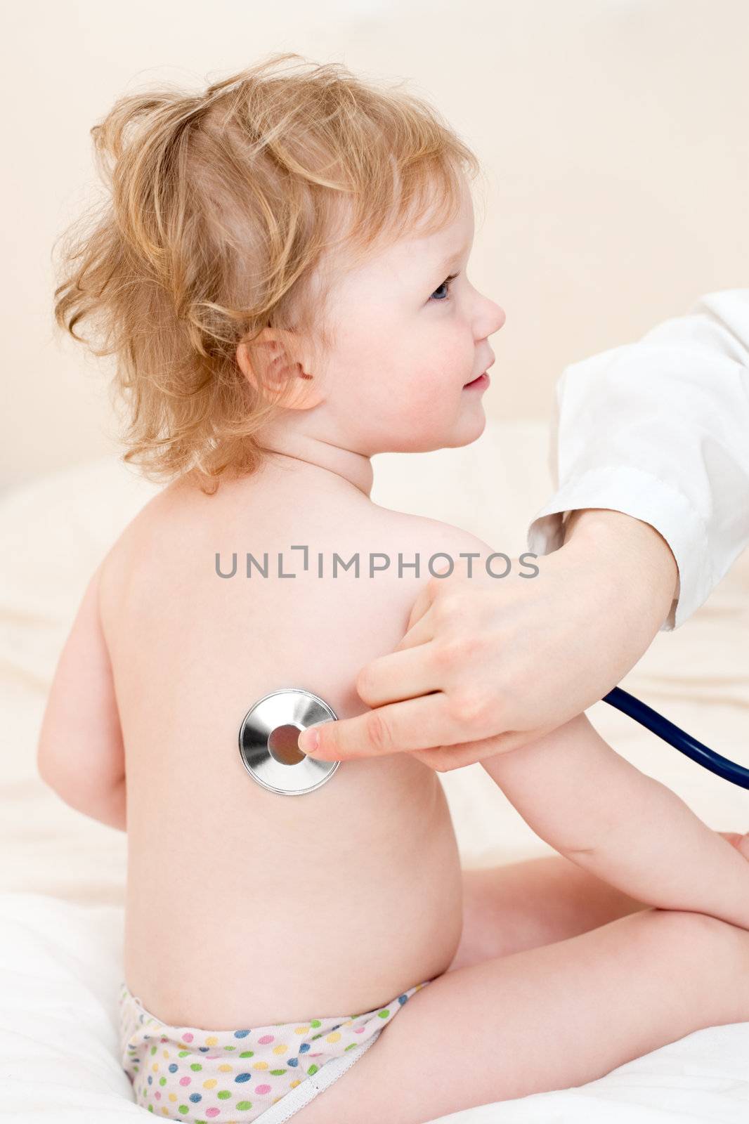 Pediatrician examining little girl with stethoscope