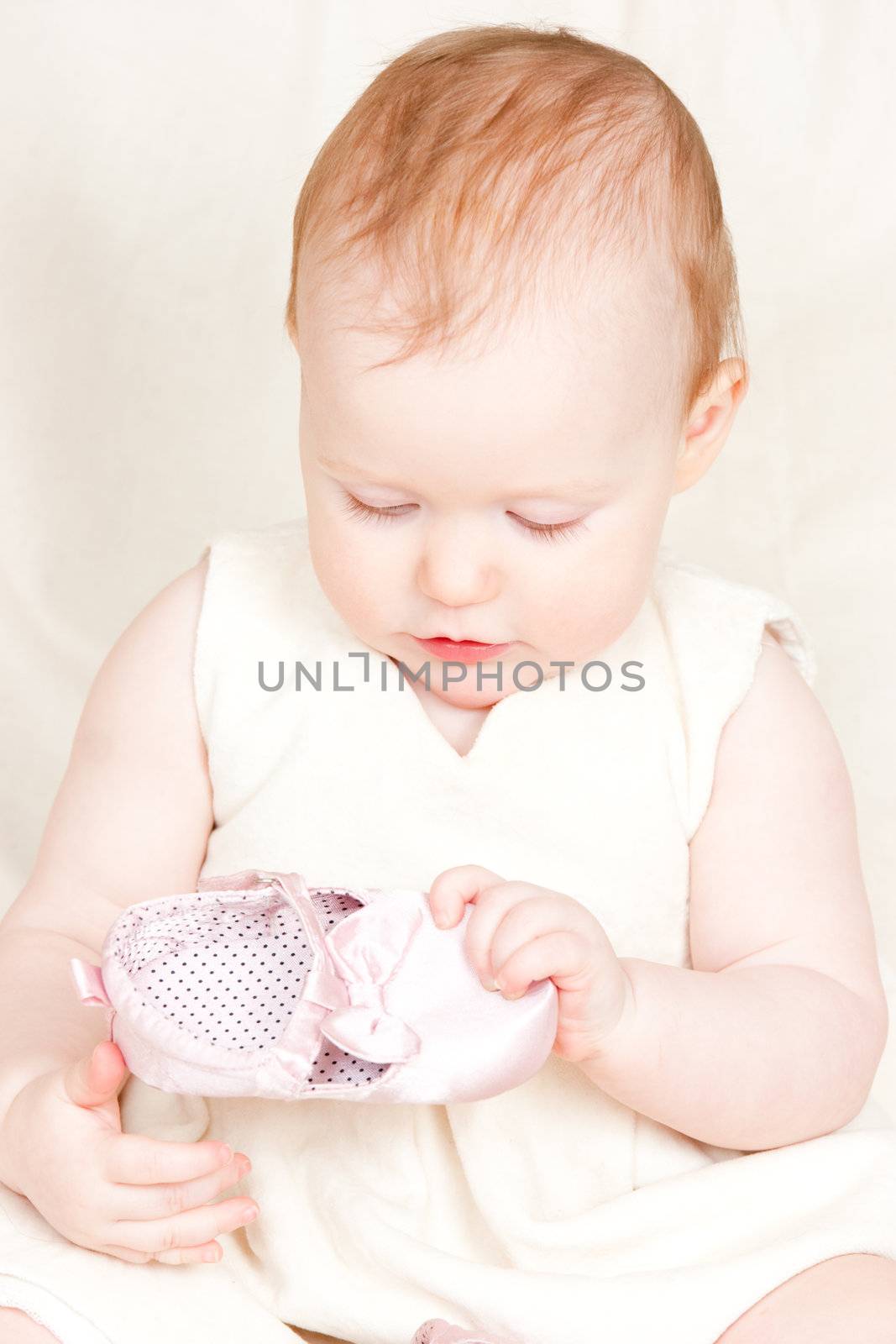 Little baby girl playing with shoe