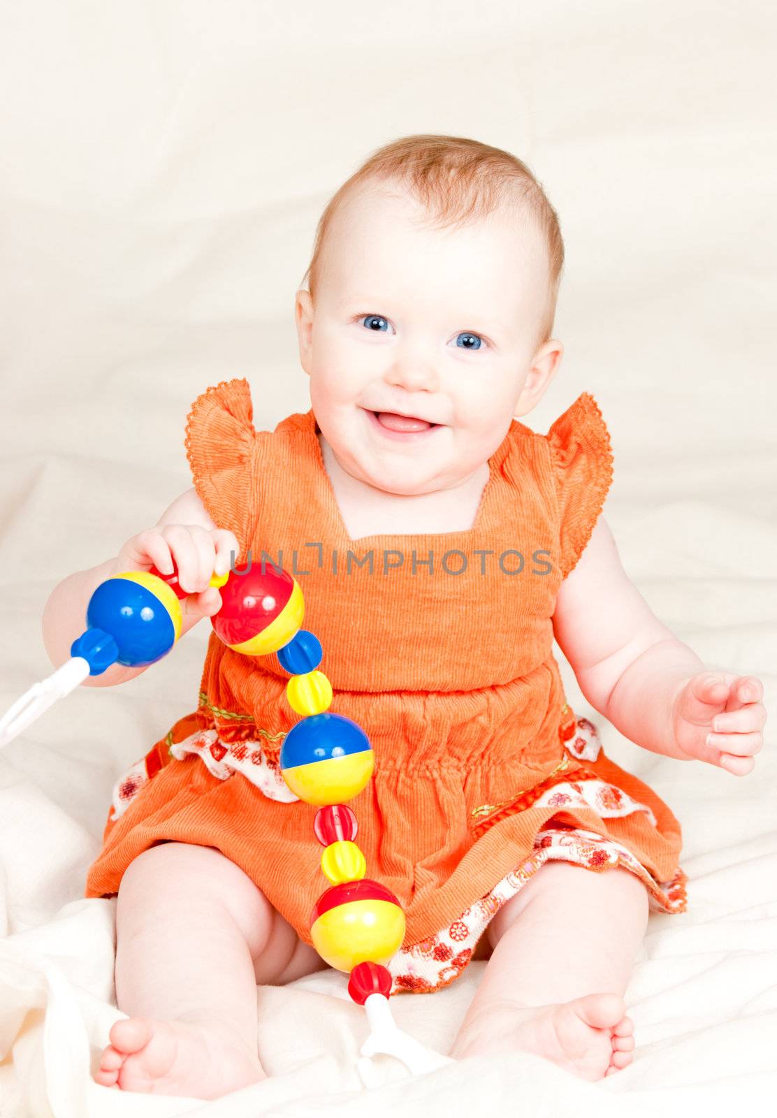 Little baby girl playing with rattle