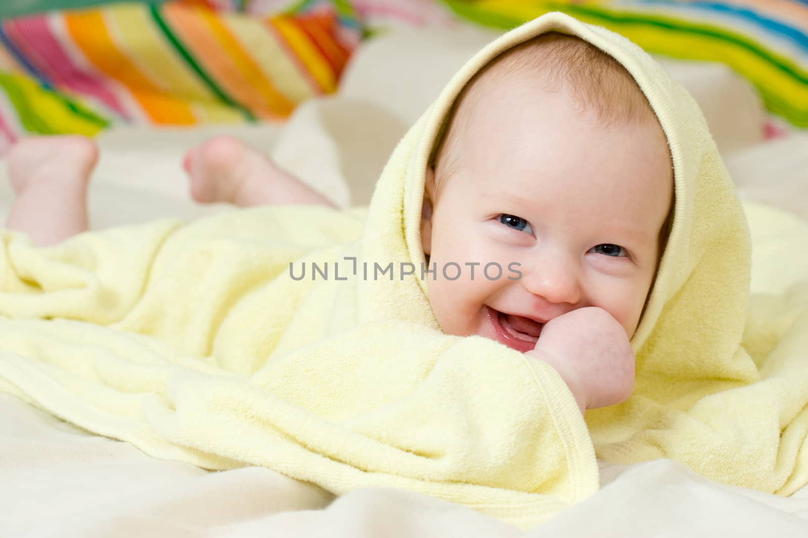 Happy four month baby girl in towel
