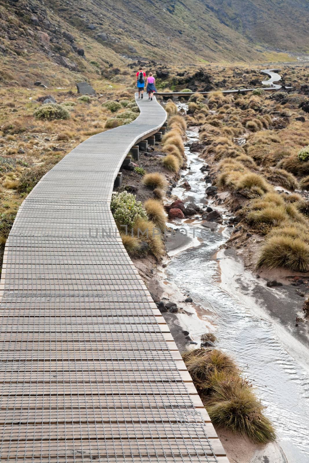 Couple walking on public track at Tongariro National Park, New Zealand