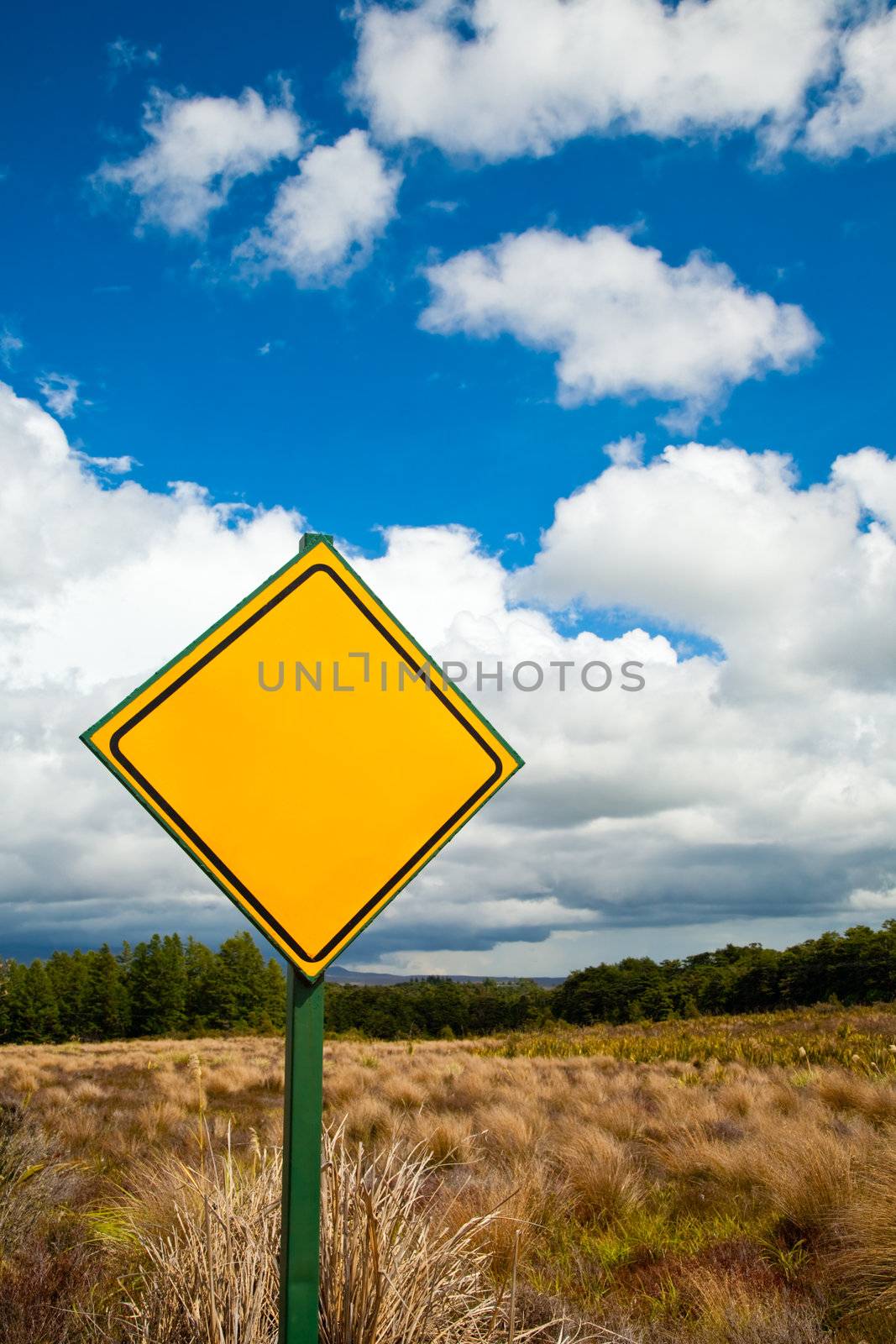 Blank yellow road sign against cloudy sky