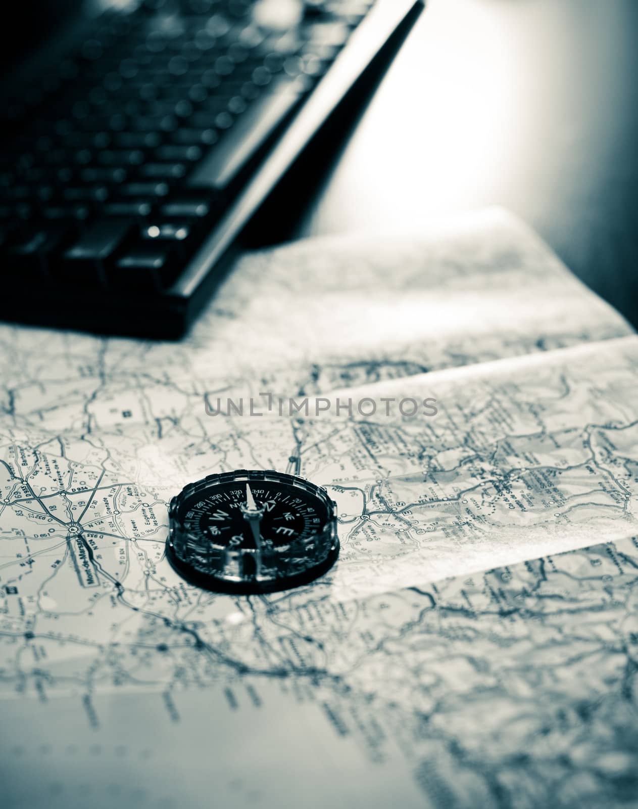 Compass and map on a table with keyboard, very shallow DOF