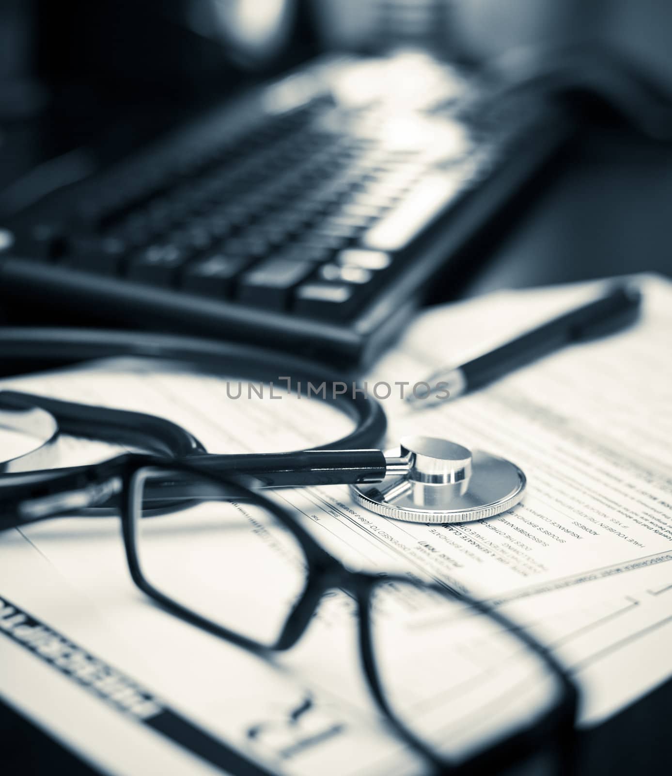 Stethoscope on a prescription form with glasses pen and keyboard, very shallow DOF
