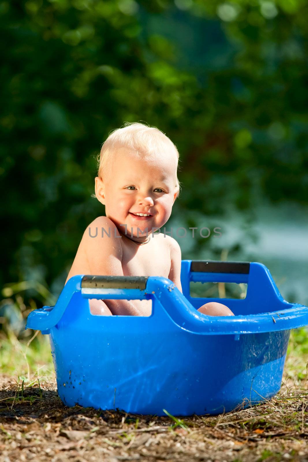 Happy baby girl having a bath outside