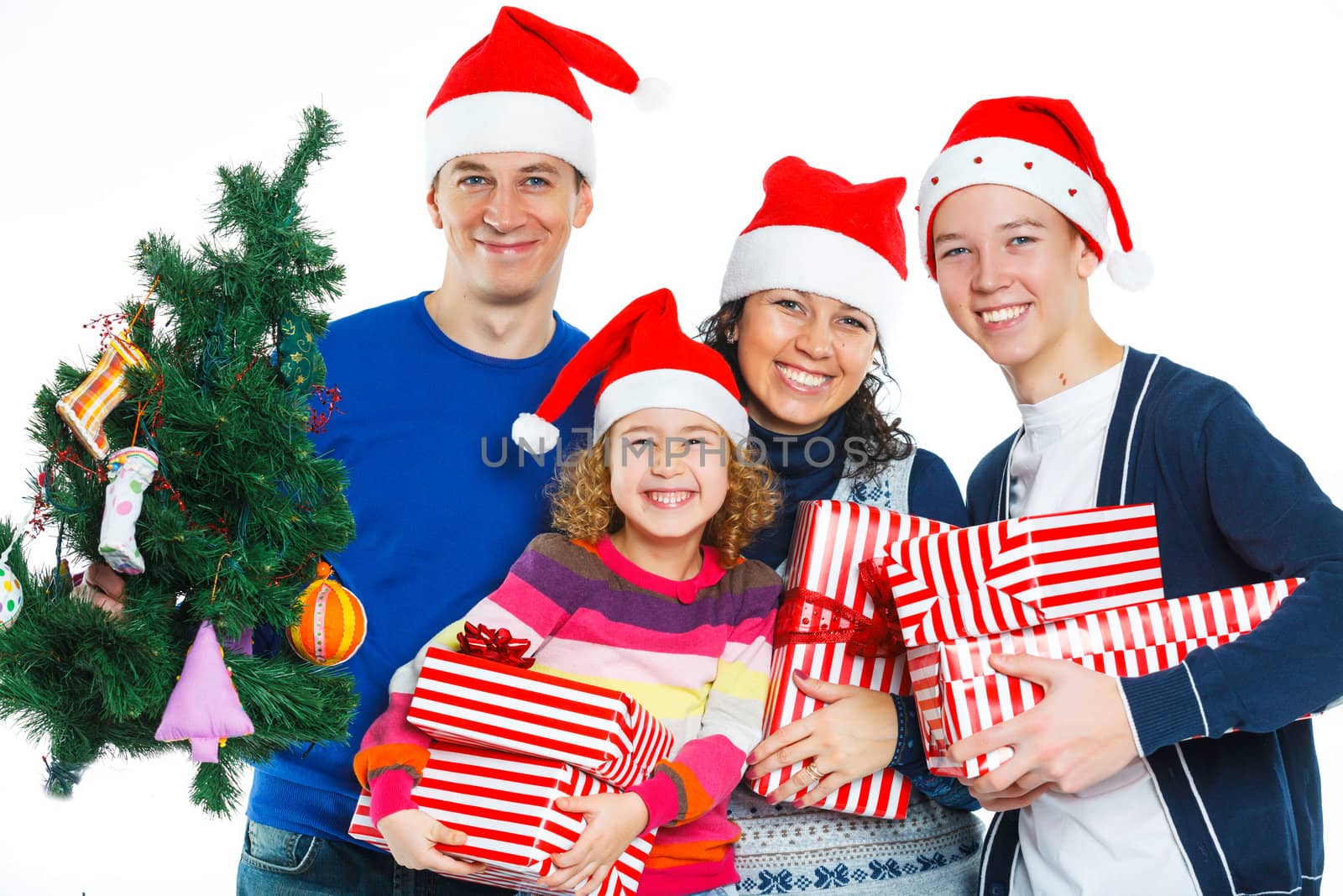 Portrait of friendly family in Santa's hat with gift box and christmas tree, isolated on white