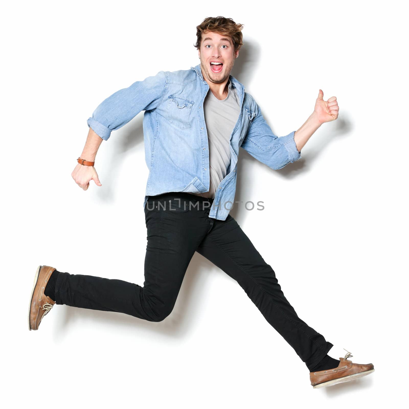 Jumping man happy excited. Funny portrait on young casual male male model in humorous jump on white background.