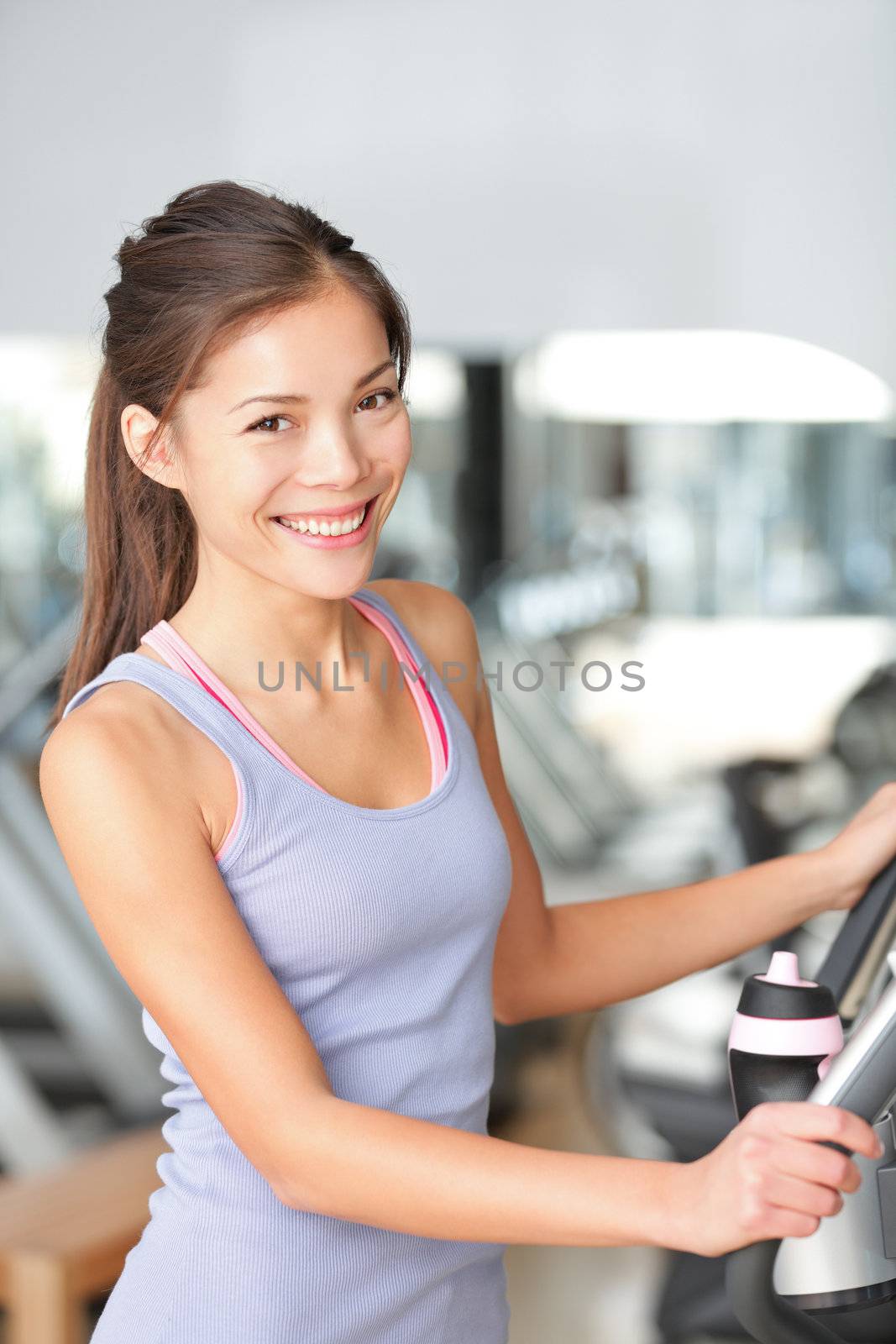 Fitness woman in gym training and working out on moonwalker gym equipment. Beautiful young multiracial Asian Chinese / Caucasian female model.