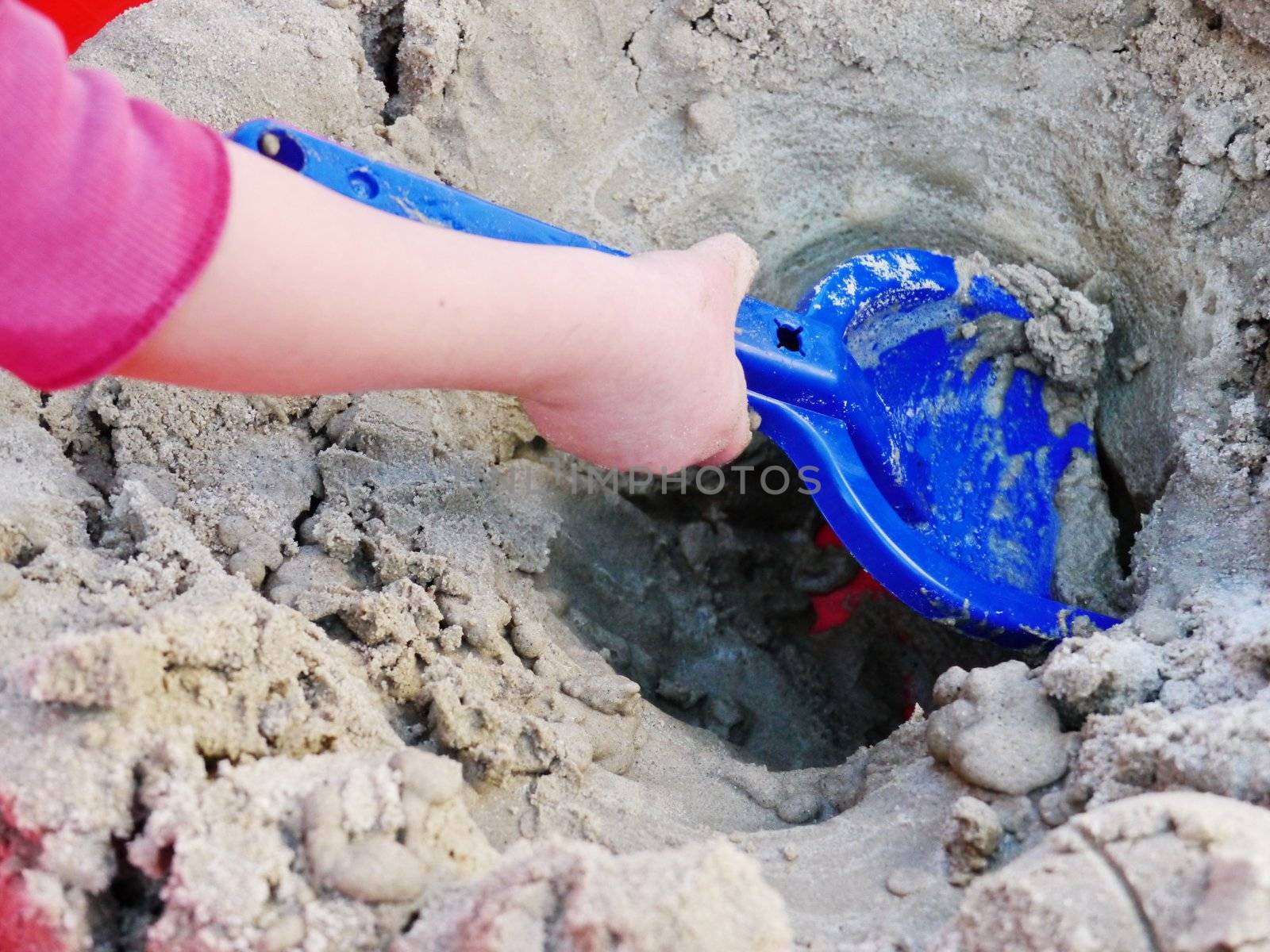 The Child game of sandbox. In frame only hands.