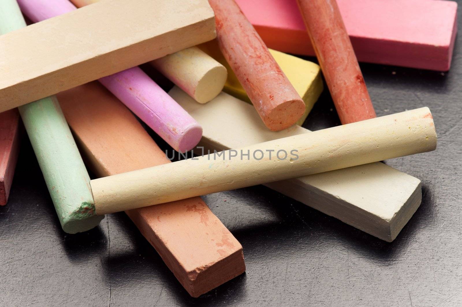 Close-up of colorful large chalk sticks on blackboard