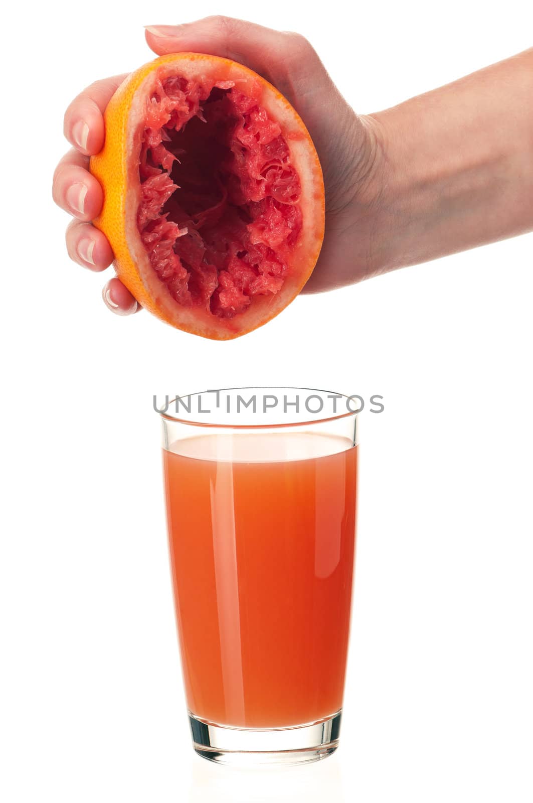 Glass of fresh grapefruit juice and hand with half of grapefruit on white background