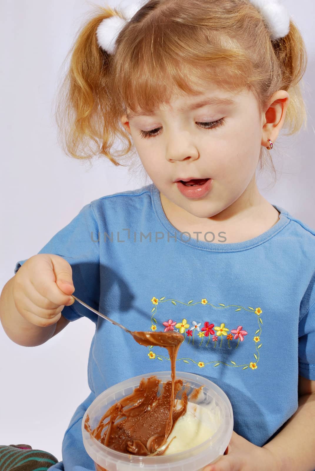 Little girl with chocolate cream studio shot