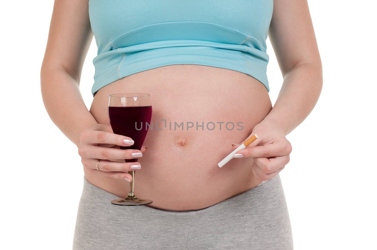 Pregnant belly with wine and cigarettes - isolated over a white background. Third trimester.