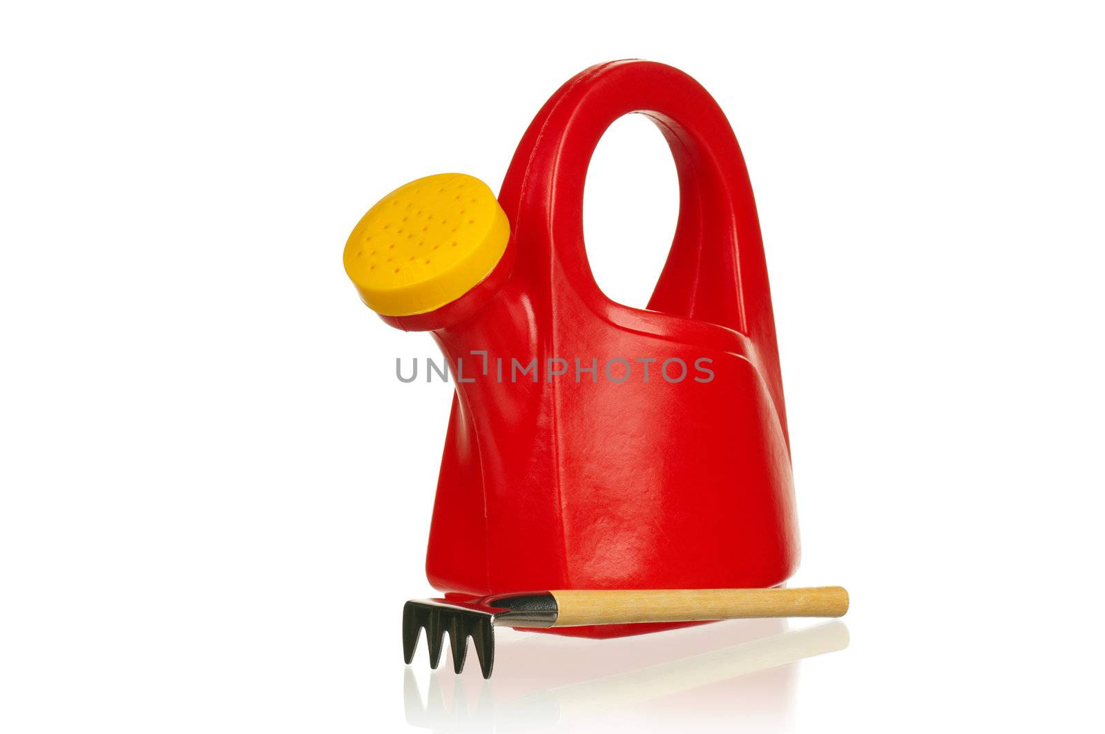 Plastic red watering can and rake on a white background