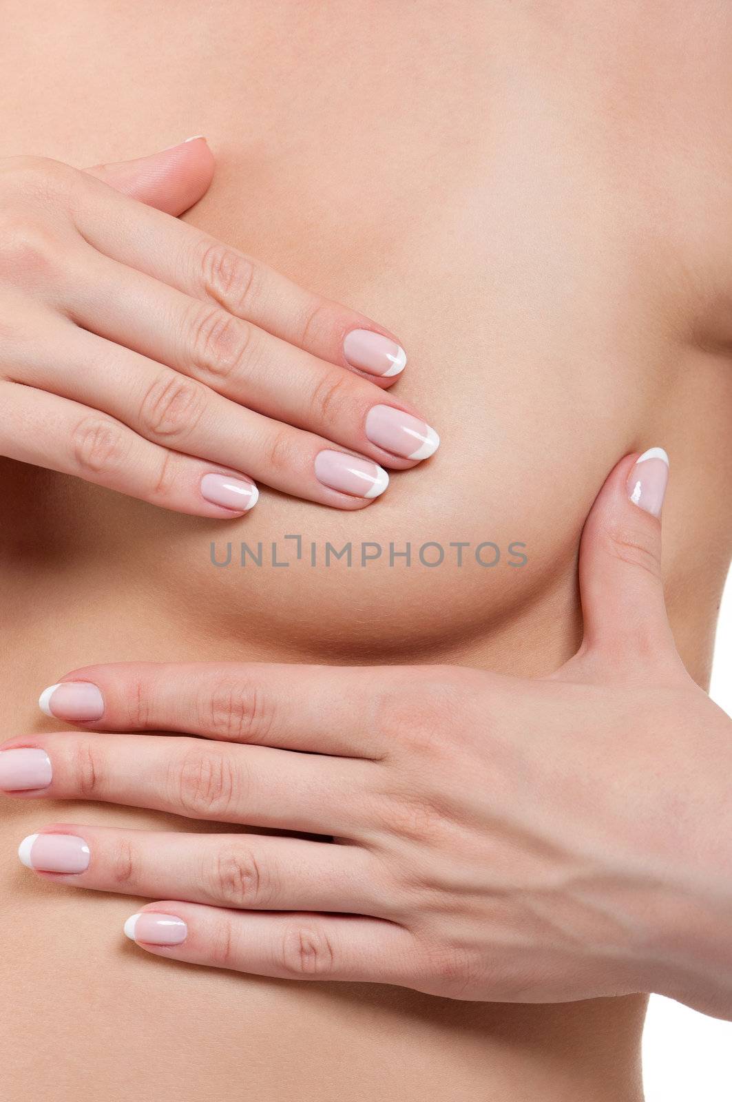 Young woman examining her breast for lumps or signs of breast cancer