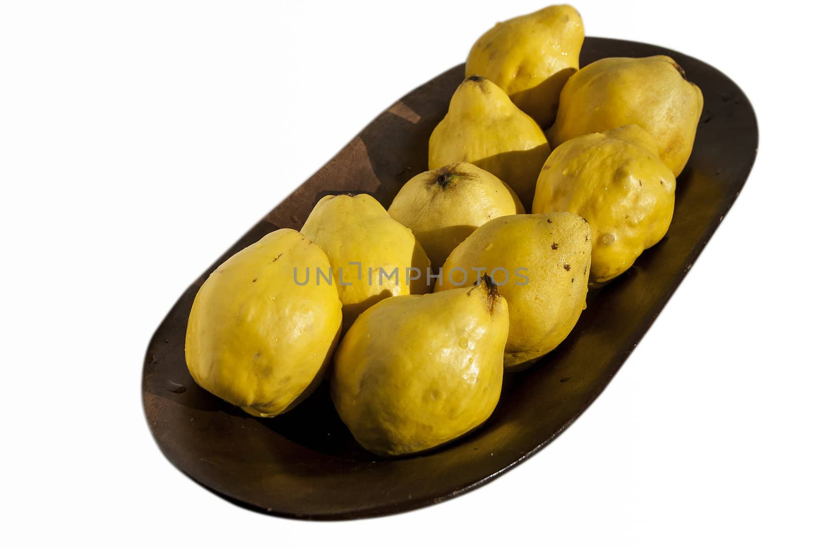 Organic quinces in wooden bowl isolated on white
