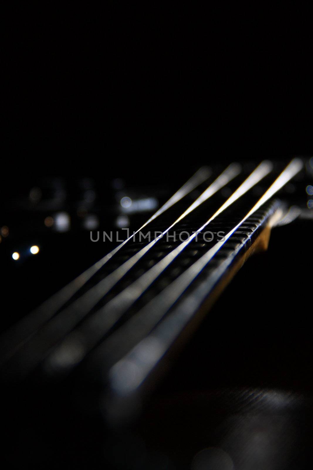 bass guitar with four strings on black ground 