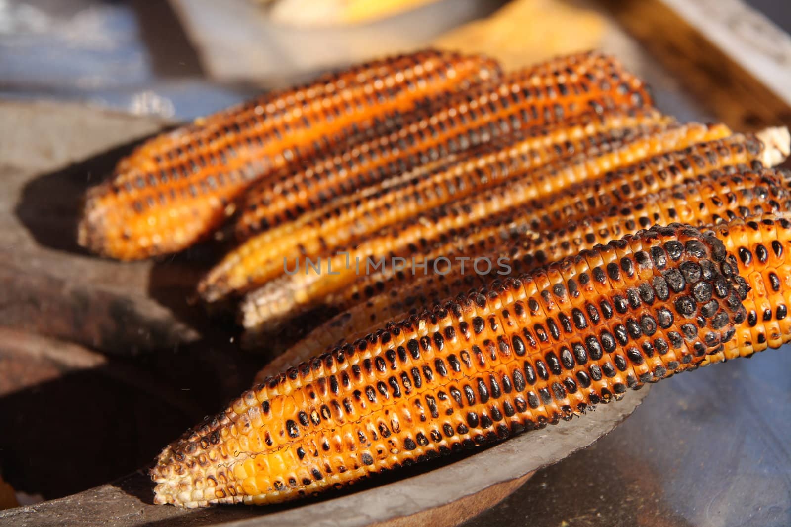 barbequed corn with black spots on it 