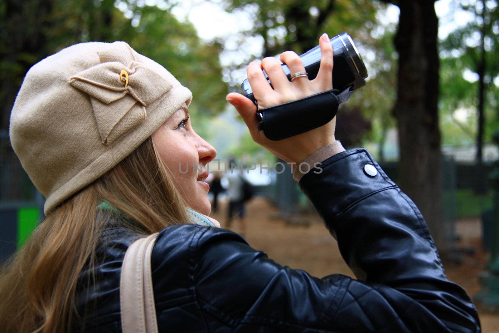 beautiful girl holds camera for filming on street