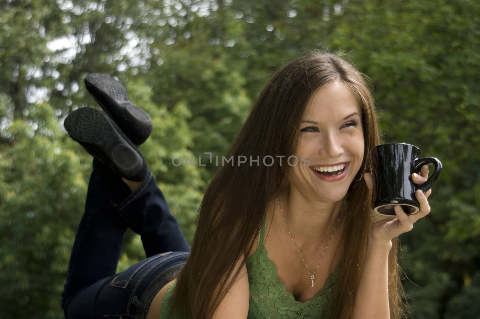 An attractive woman enjoys coffee in the park