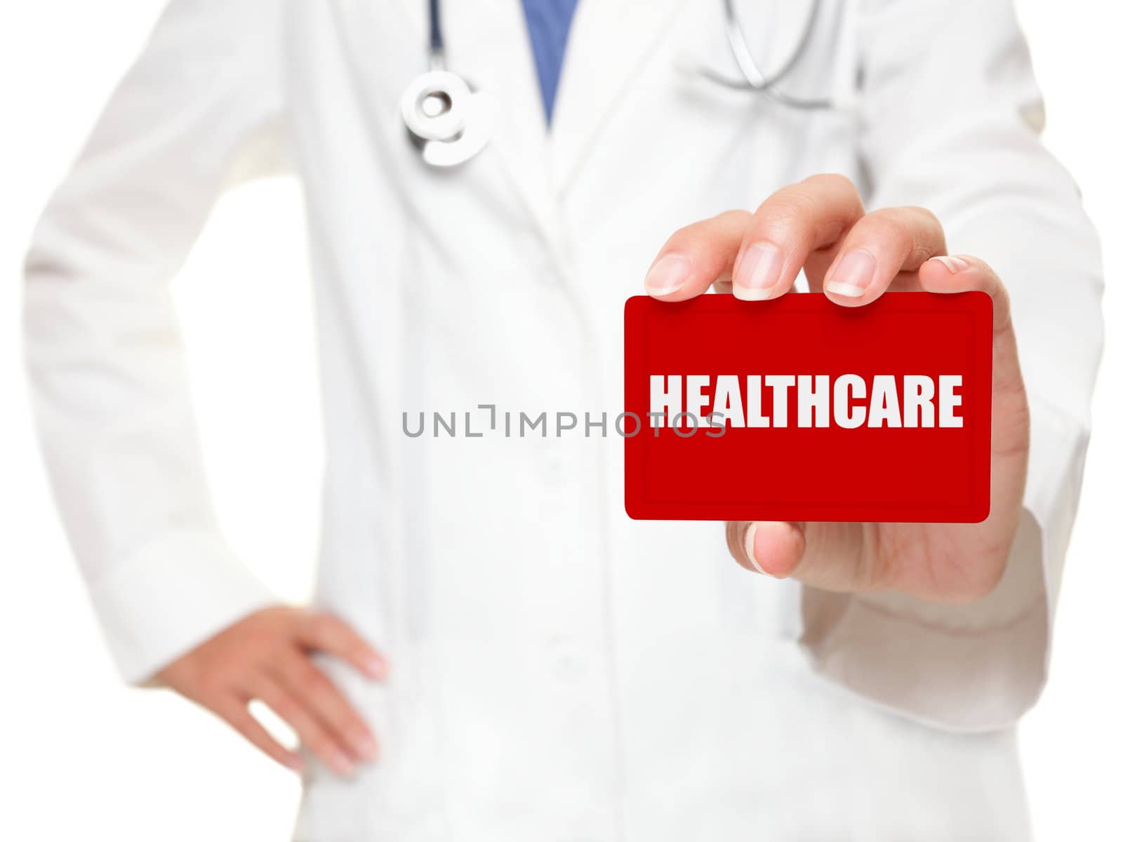 Female doctor holding a red businesscard with white capital lettering HEALTHCARE in her hand, cropped view image with selective focus to the card