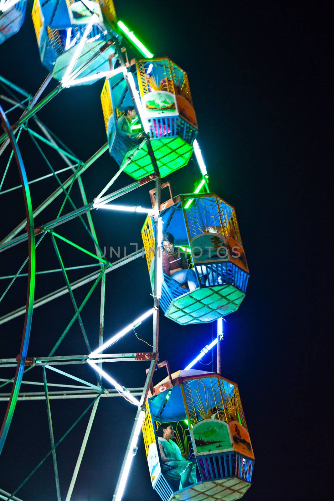 people enjoy the big wheel in the amusement park in Delhi by meinzahn