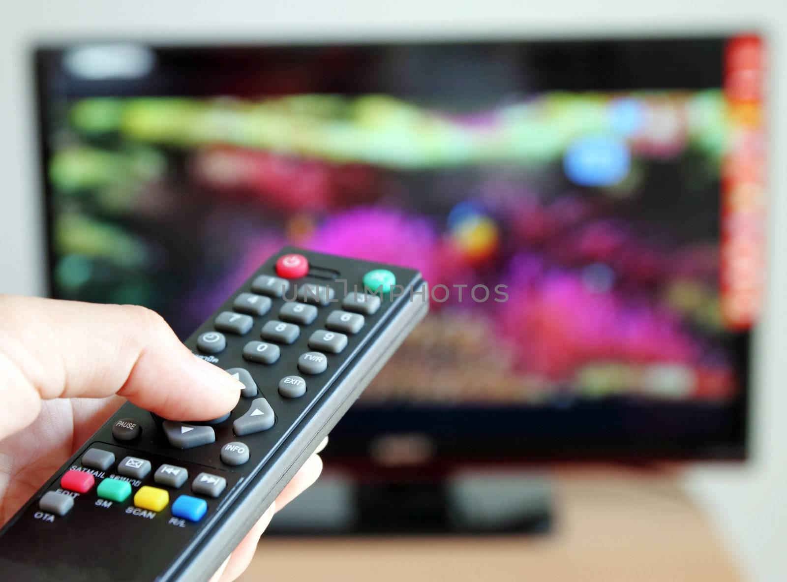 Hand pointing a tv remote control towards the television by geargodz