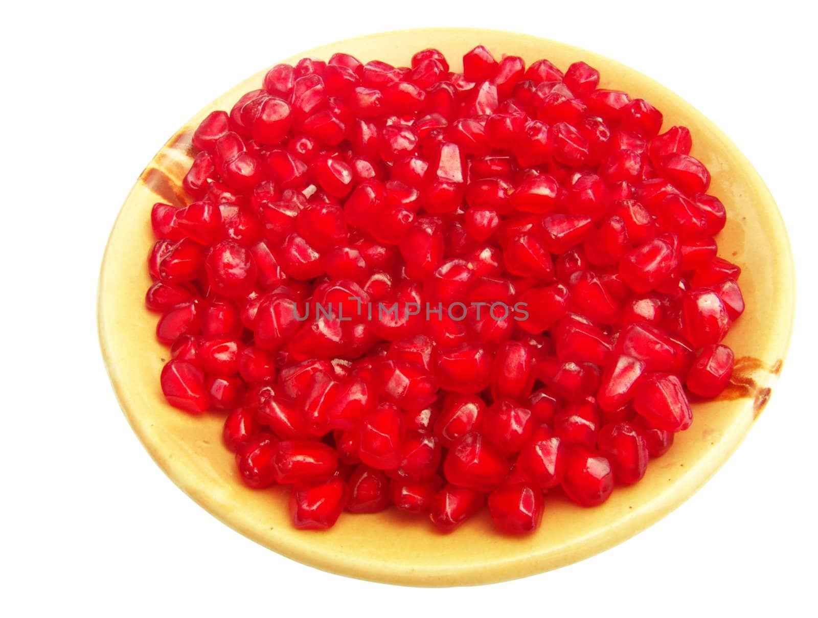 pomegranate (Punica granatum) seeds on a plate isolated on white