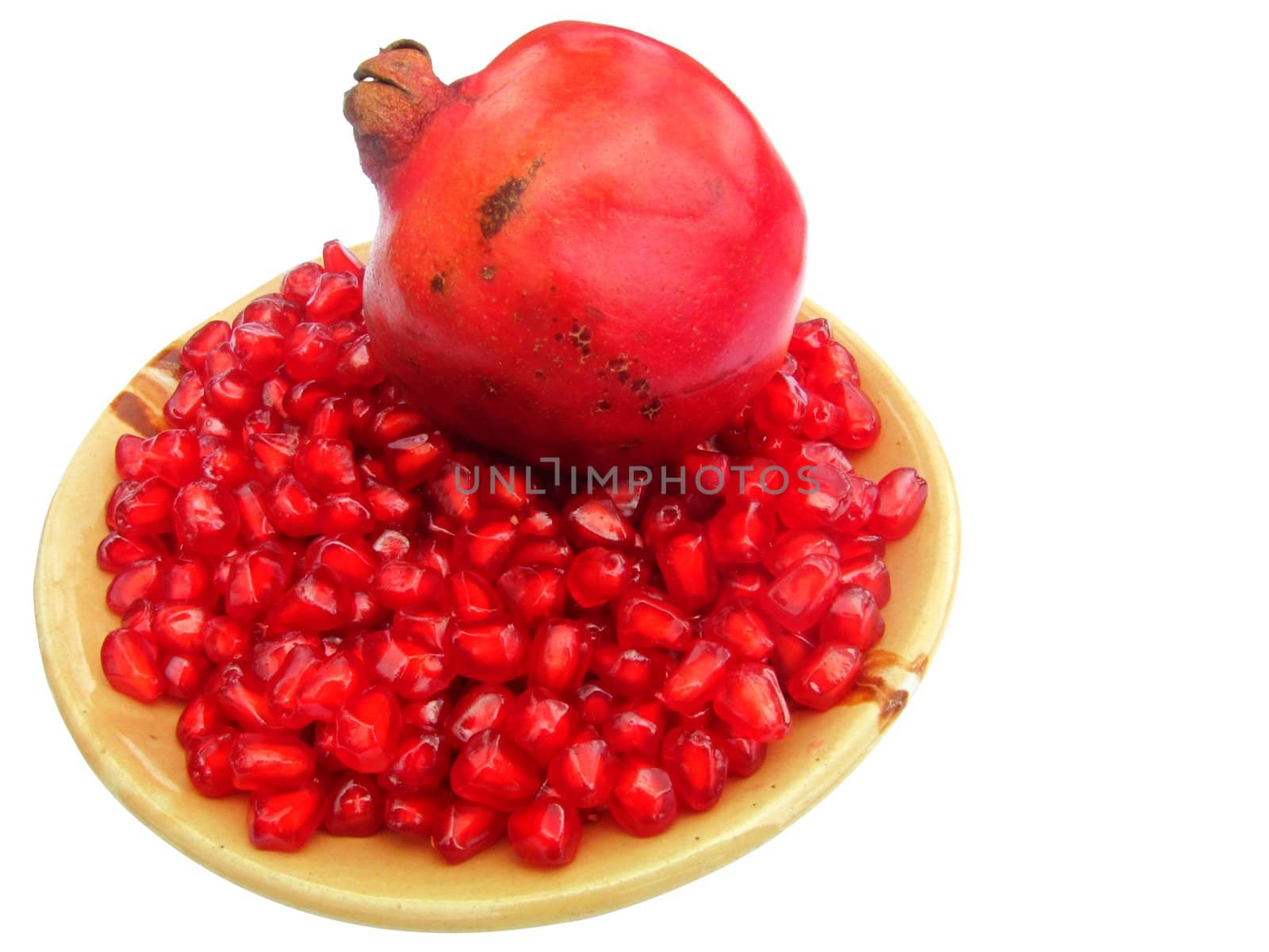 pomegranate (Punica granatum) fruit with seeds on a plate isolated on white