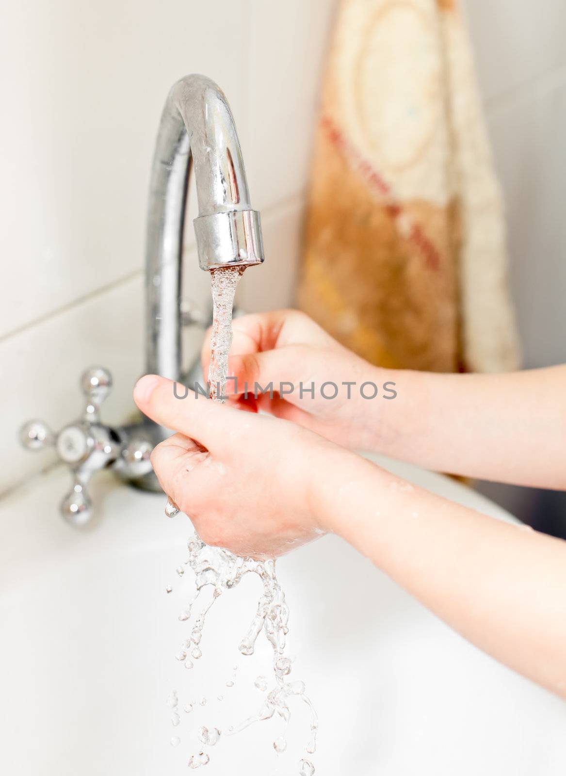 Little girl washing her hands in bathroom, shallow focus
