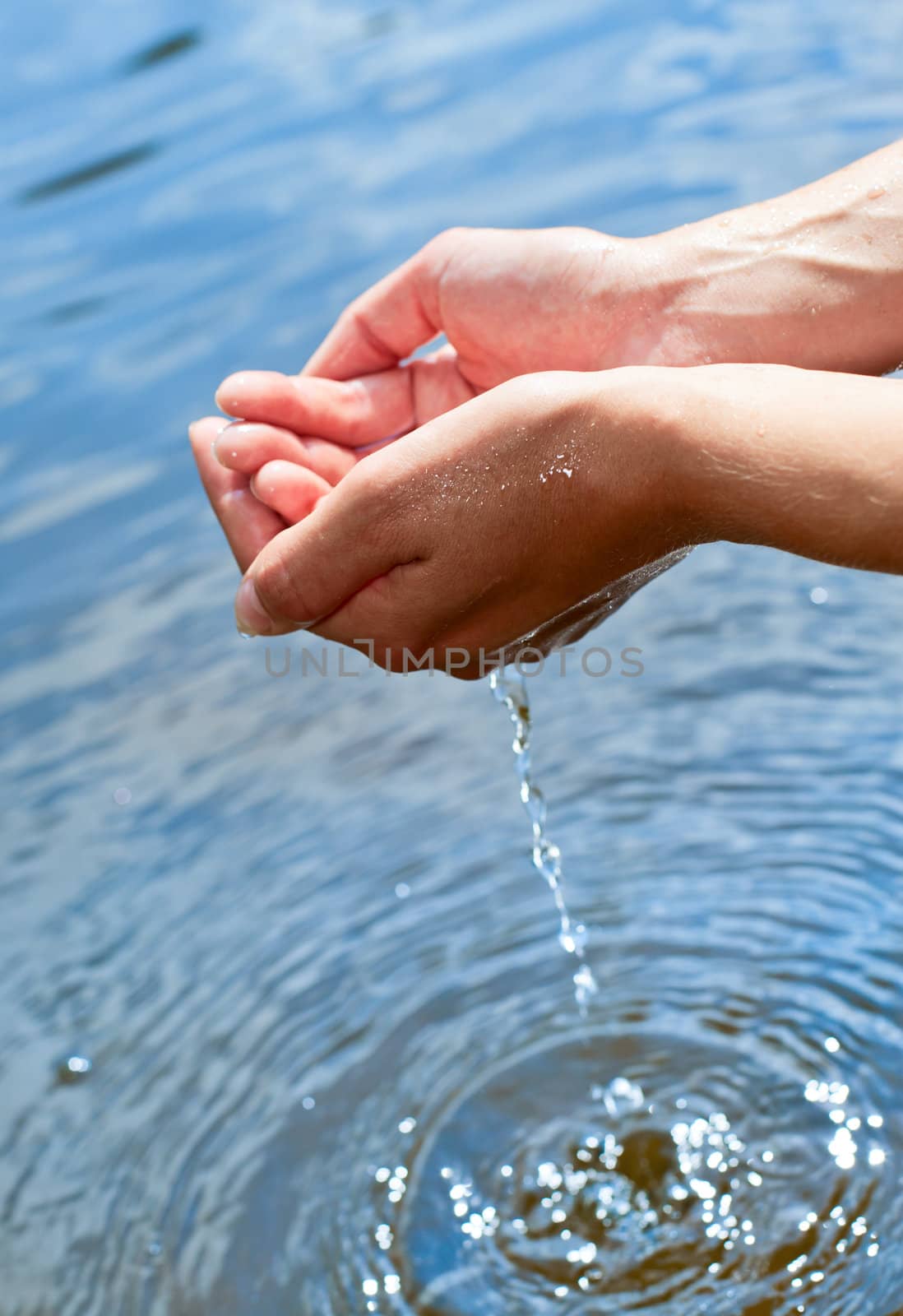 Water pouring out of a young woman's hands