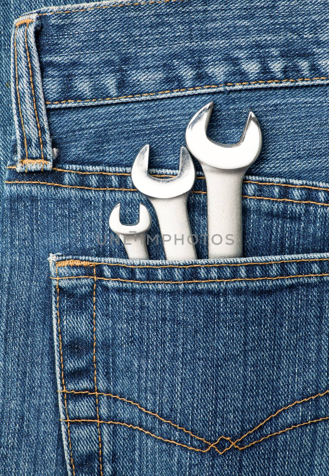 Blue jeans pocket with chrome lug wrenches