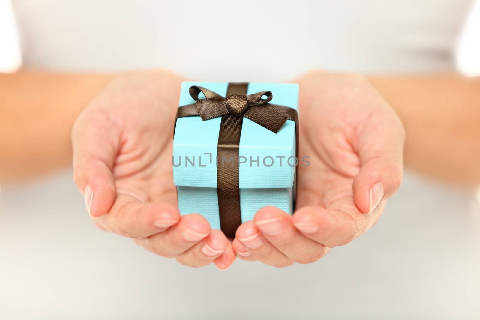 Female hands holding a small present - close up