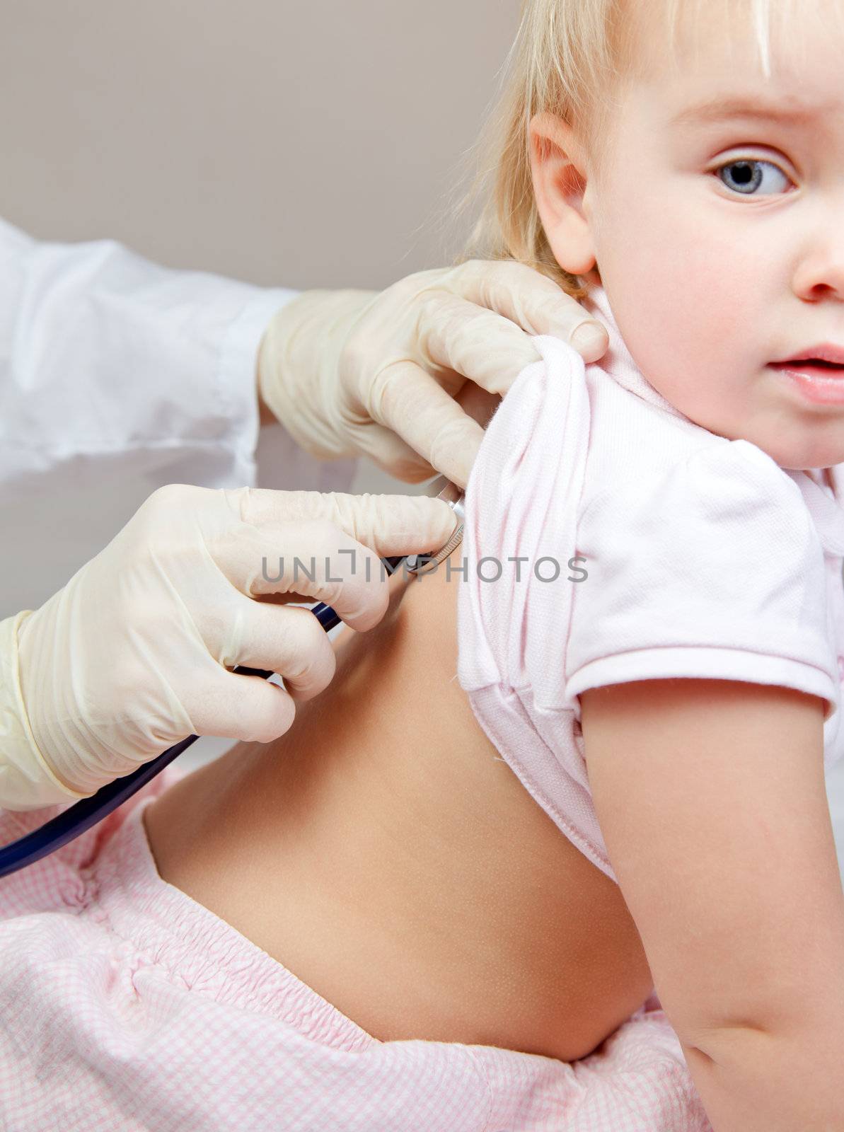 Pediatrician examining little girl with stethoscope