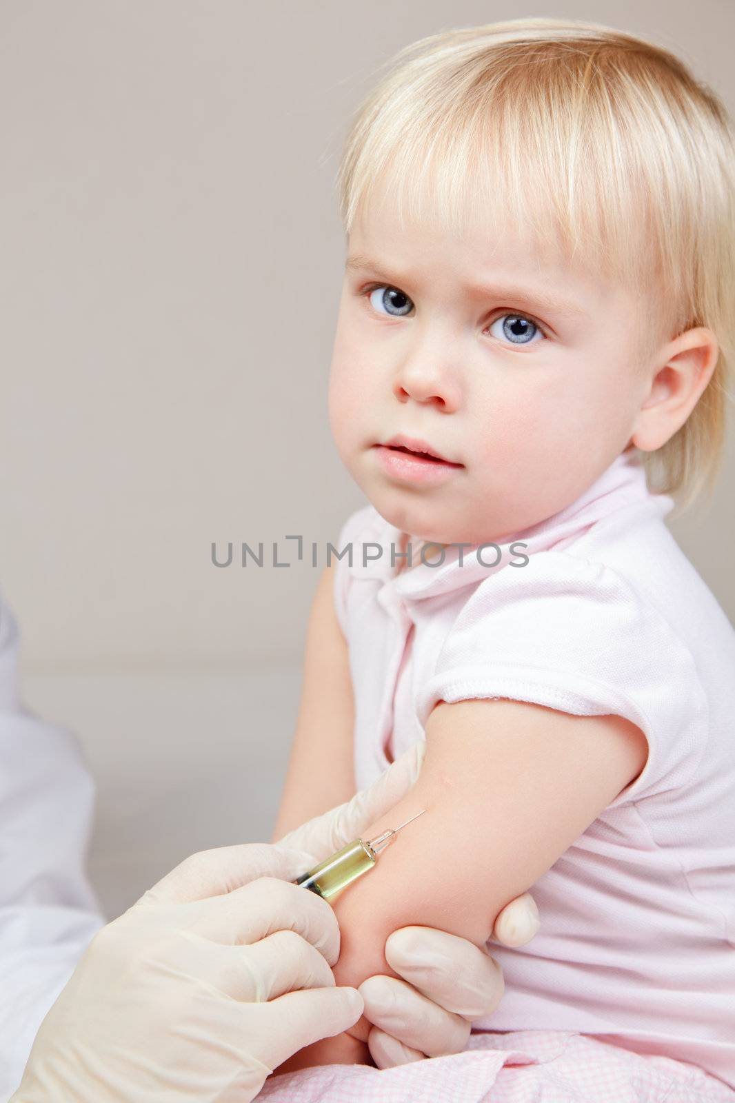 Doctor giving a child an intramuscular injection in arm