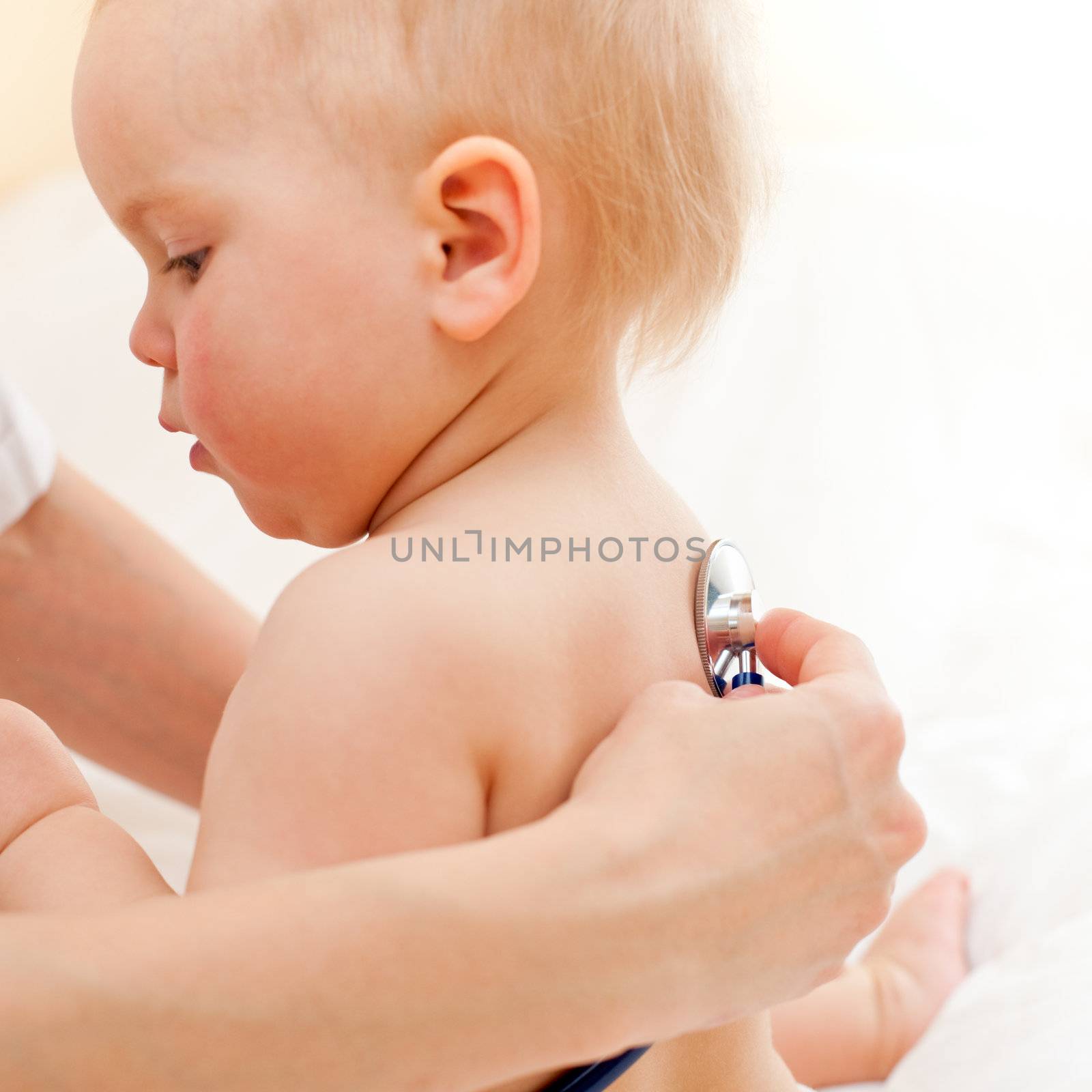 Pediatrician examining little baby girl with stethoscope