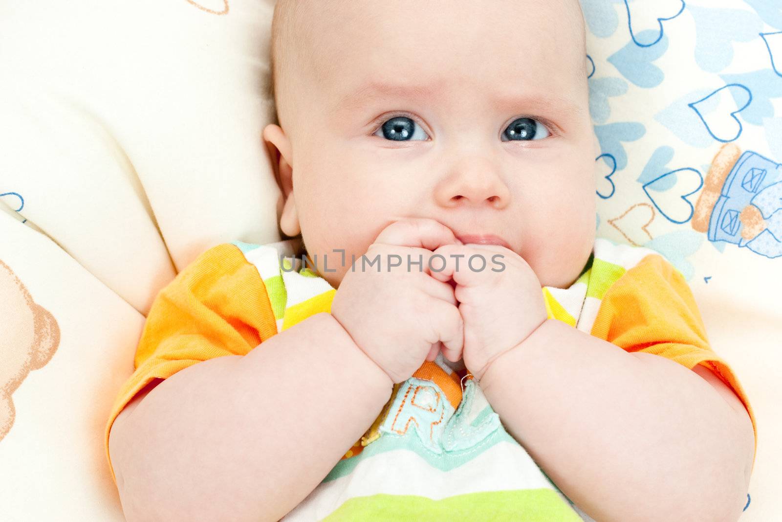 Cute little baby girl holding her hands in mouth