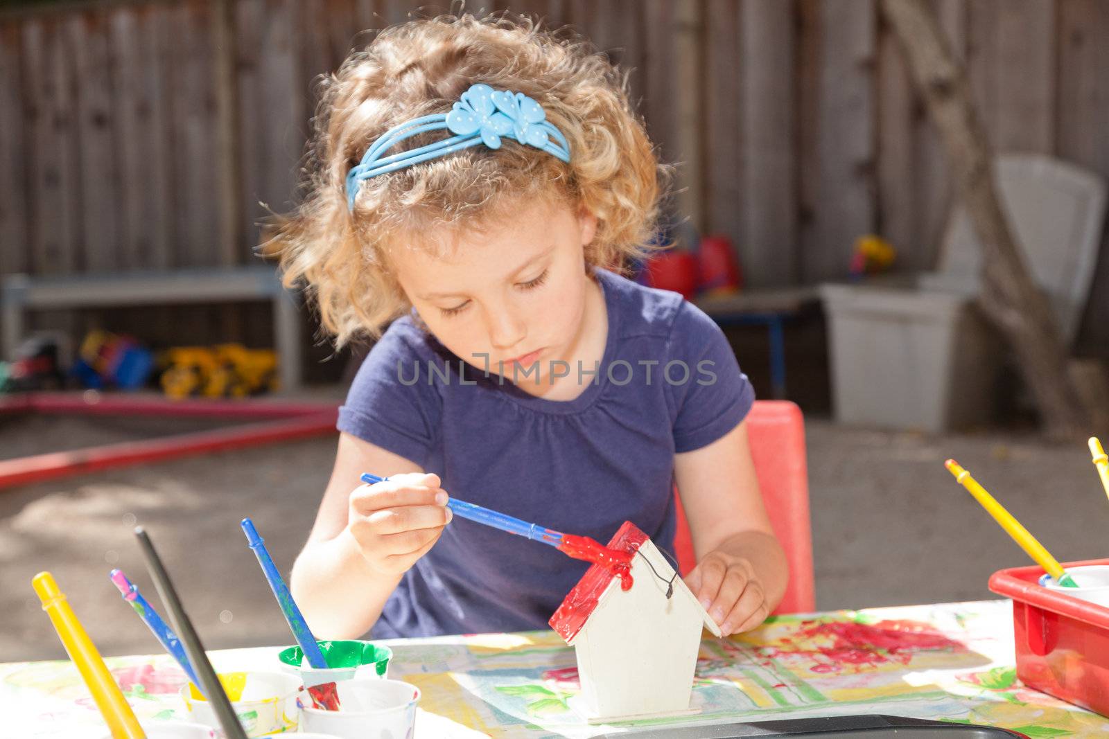 Cute little baby girl having fun painting at art class