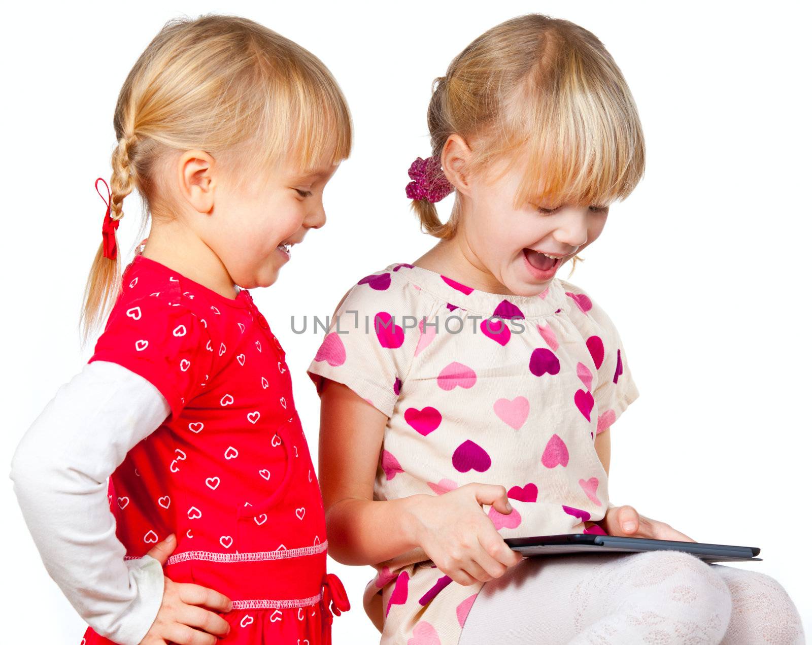 Two happy girls playing with a touch pad