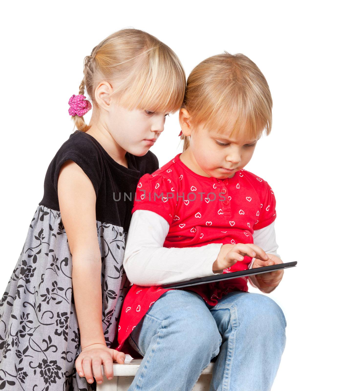 Two serious girls playing with a touch pad