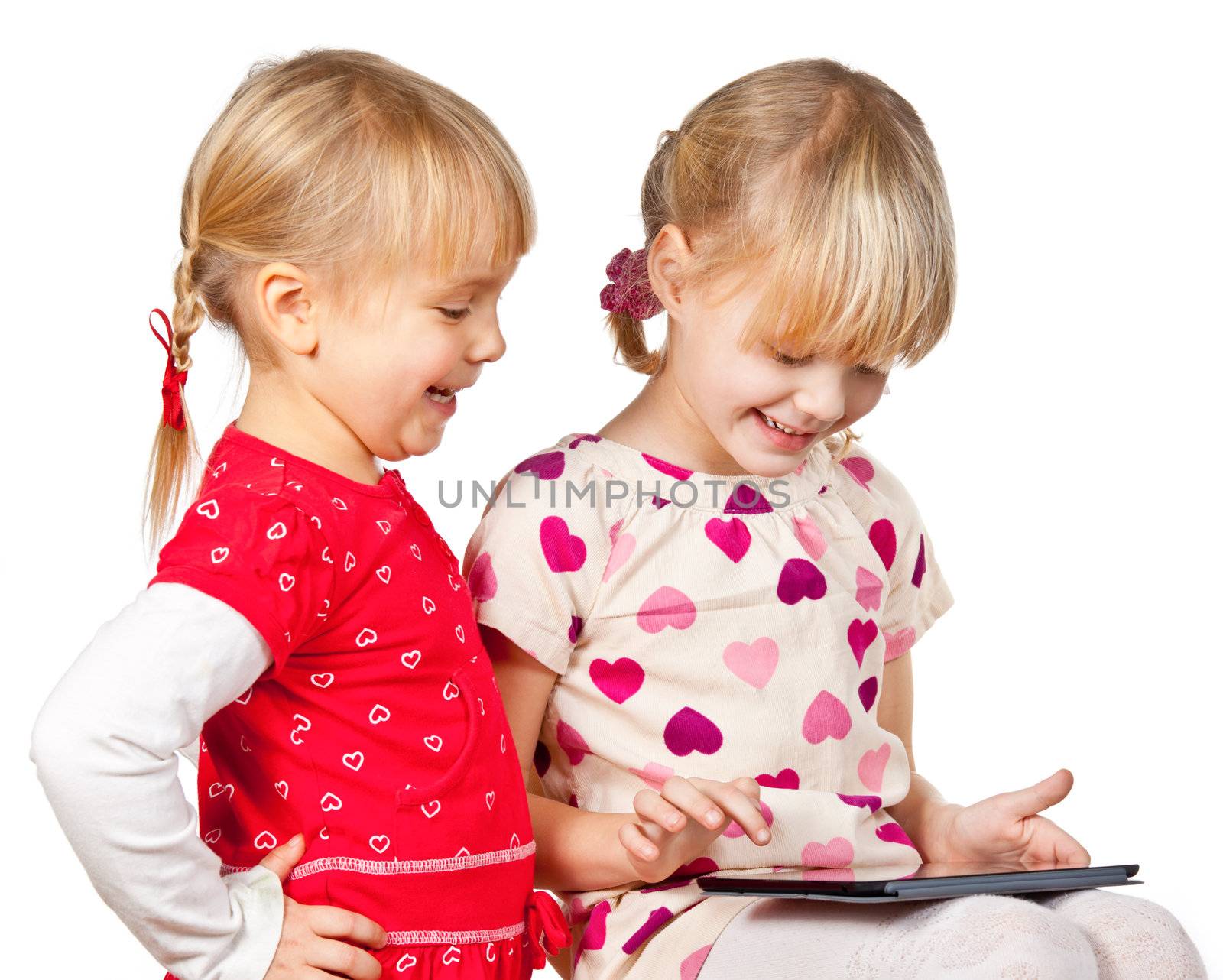 Two happy girls playing with a touch pad