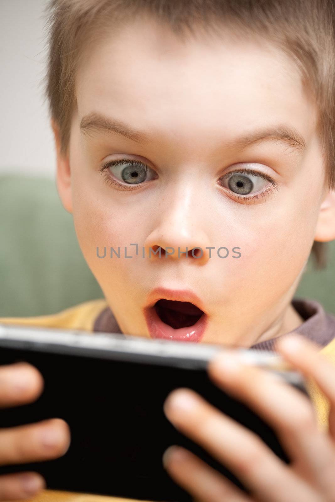 Boy playing game console by naumoid