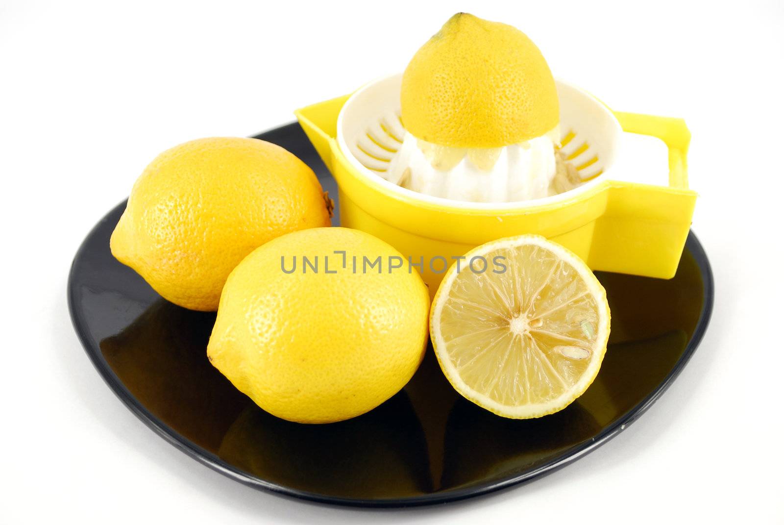 Lemon and strainer on black dish