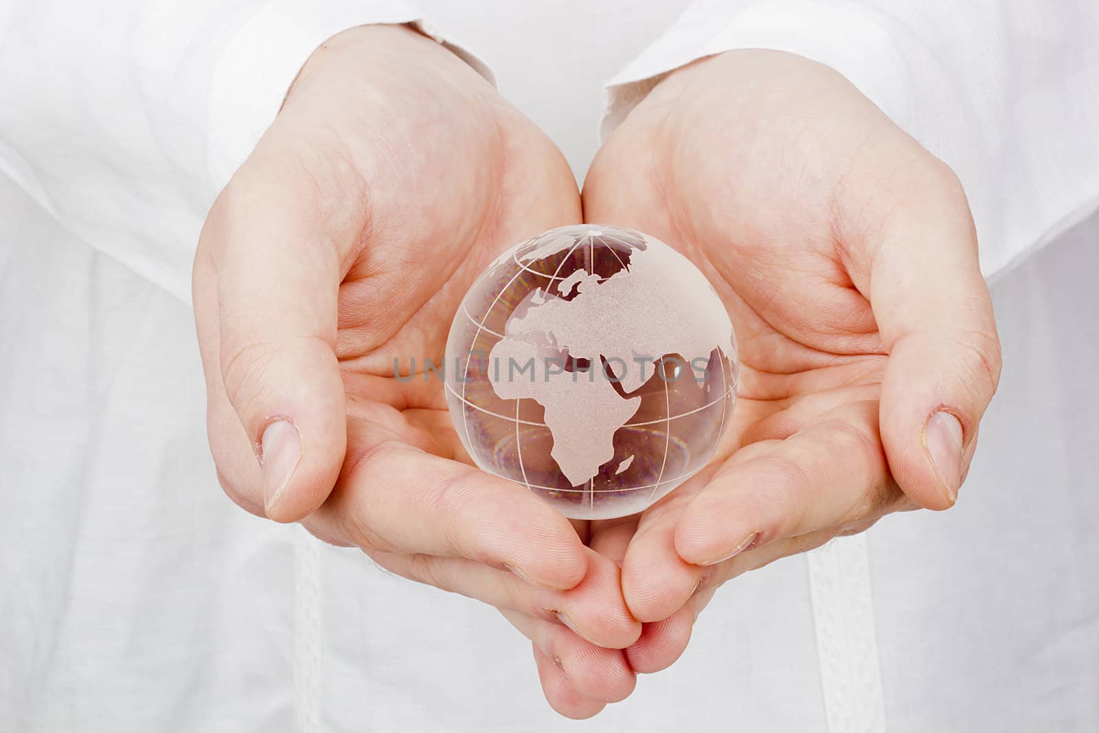 Close-up photograph of a glass globe in man's hands.