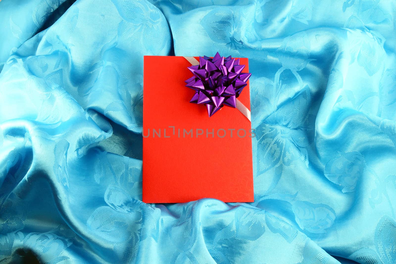 red gift card with ribbon on blue satin by geargodz