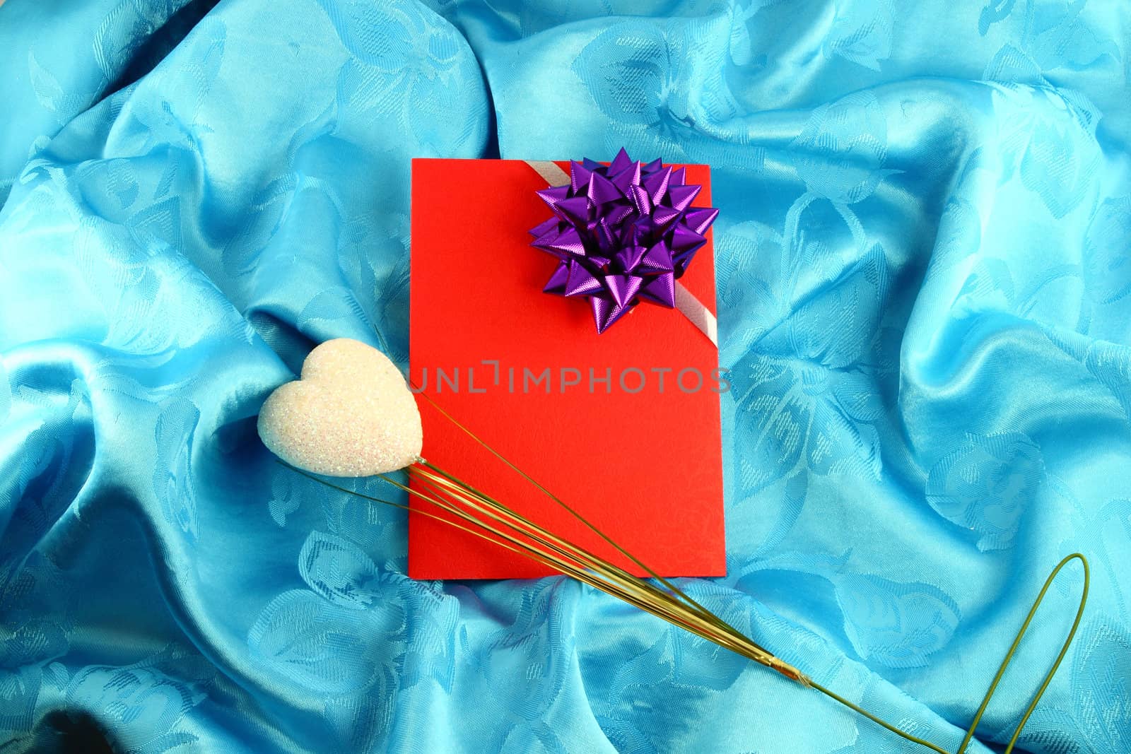 red gift card with ribbon on blue satin by geargodz