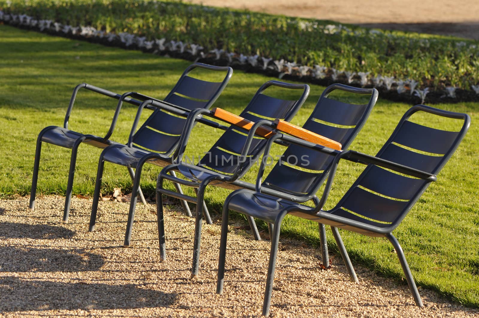 Four metallic chairs in a city garden